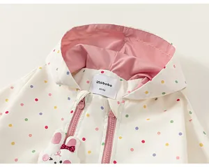 Close-up detail of children's polka dot windbreaker jacket featuring cute bunny decor
