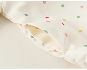 Detailed macro view showing the pocket and vibrant polka dot print on child's windbreaker