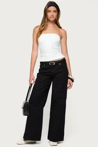 Jean large noir à pois pour femme porté avec un haut bandeau blanc vraiment élégant