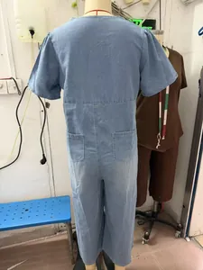 Back view detail of loose short sleeve light blue washed denim jumpsuit with pockets