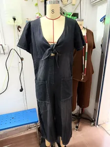 Detailed view of women's casual loose black denim jumpsuit with V-neck tie-front design
