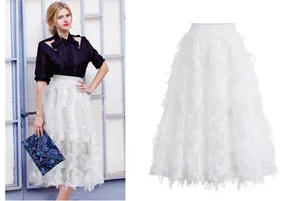 Detailed view of white midi skirt featuring unique leaf-shaped cutout texture and elegant fit.