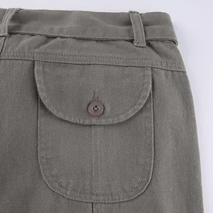 Close-up detail of vintage cargo pants featuring a buttoned flap pocket and twill texture.