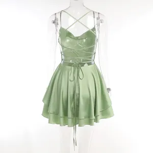 Detailed back view of a light green satin mini dress featuring cross lace-up straps