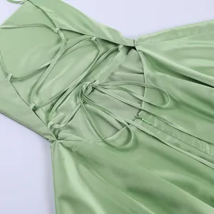 Close-up of the back lace-up and zipper details of a sage green satin dress.