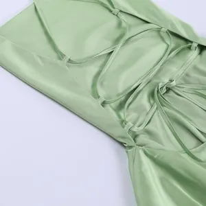 Detailed close-up view of a mint green satin dress featuring an elegant backless lace-up design
