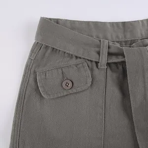 Detail view of waistband and decorative button pocket on vintage grey cargo pants