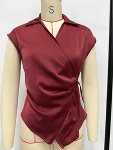 Detail view of elegant burgundy satin sleeveless wrap blouse shown on mannequin