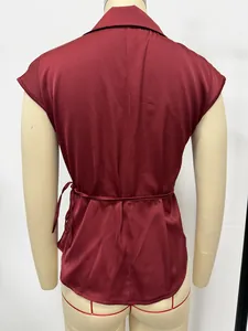 Back view of a burgundy satin sleeveless shirt with a tie-waist detail on a mannequin