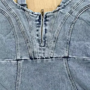 Détail en gros plan d'une robe en denim vieilli à col en U avec fermeture éclair