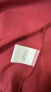 Close-up detail of the garment care label showing 90% polyester and 10% elastane composition