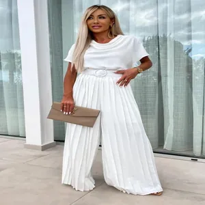 Elegant white pleated wide-leg jumpsuit detail showing high-quality fabric and waist belt