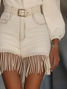 Primer plano de vestido blanco con flecos, cinturón y detalle de mangas abullonadas