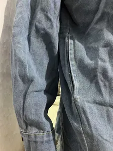 Gros plan détaillé d'une veste en jean délavé bleu avec poche latérale et texture