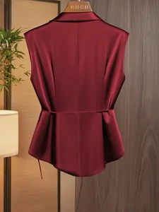 Detail of the elegant burgundy satin sleeveless top featuring a cinched waist design