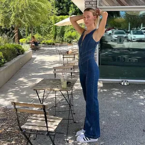Detail view of slim sleeveless high-waisted denim jumpsuit in outdoor setting