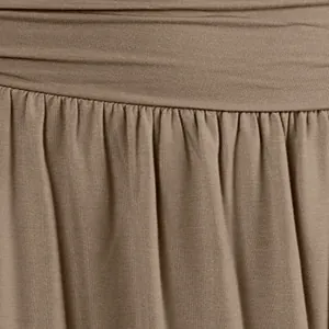 Makrodetail der plissierten Taille und des fließenden Stoffes eines khakifarbenen Midi-Rocks