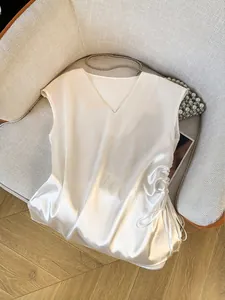Detailansicht eines eleganten weißen Satin-Oberteils mit V-Ausschnitt und Kordelzug