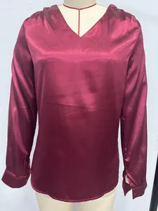 Detailed view of wine red long-sleeved satin blouse featuring elegant V-neck design
