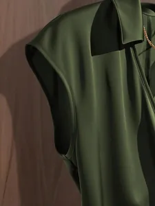 Close-up of elegant olive green satin sleeveless blouse showing premium fabric texture
