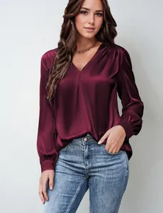 Dettaglio della blusa in raso bordeaux con scollo a V, trama pieghettata e drappeggio