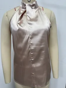 Close-up detail of champagne satin halter neck sleeveless top showing smooth fabric texture
