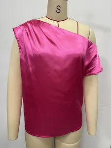Detailed view of a vibrant pink satin one-shoulder blouse displayed on a mannequin.