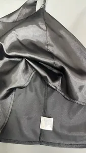 Détail de la texture du tissu en satin noir et de l'étiquette d'entretien intérieure