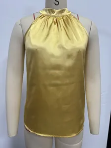 Close-up detail of a yellow satin halter neck sleeveless top with pleated neckline