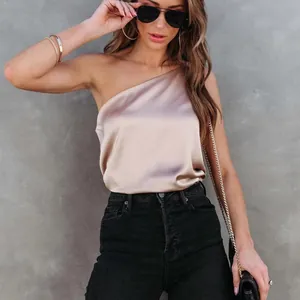 Top élégant en satin champagne à une épaule porté avec un jean noir à taille haute chic
