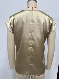 Detaillierte Rückansicht einer eleganten Damenbluse aus goldenem Satin mit Fledermausärmeln