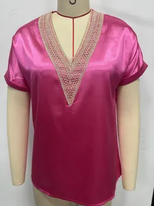 Detailed view of the elegant lace trim on a vibrant magenta V-neck satin blouse