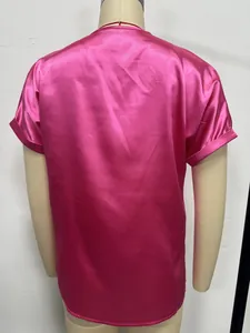 Back view of a hot pink satin short-sleeved top showing glossy faux silk texture detail.