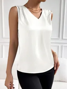 Detalle de una blusa de satén blanco sin mangas con elegantes pliegues en el escote en V