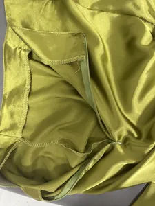 Gros plan sur la fermeture éclair invisible d'une jupe midi en satin vert
