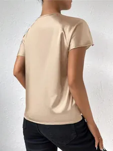 Detail of satin short-sleeve top in champagne gold showing back view and silky texture.