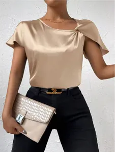 Detail of champagne satin top featuring elegant shoulder twist and silk-like texture