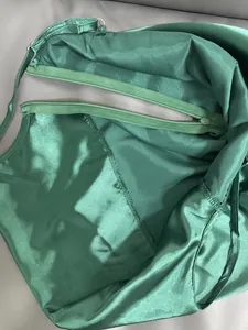 Gros plan sur le tissu satiné vert et la fermeture éclair de haute qualité de cette robe.