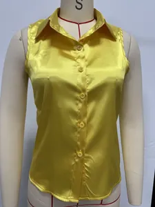 Detalle de una camisa sin mangas de satén amarillo con acabado brillante y botones
