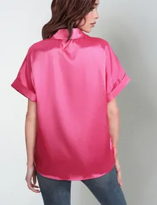 Back view of a vibrant pink satin short-sleeved button-down shirt on a female model