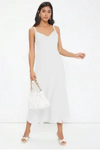 Close-up of elegant white satin slip dress with cowl neck and spaghetti straps