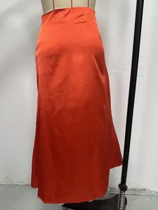 Elegant orange high-waisted satin maxi skirt with side slit and fishtail hem detail.