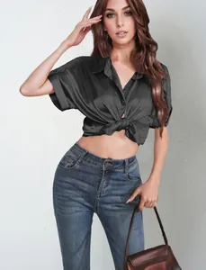 Detail view of a black satin short-sleeve button-down shirt tied at the waist for women.