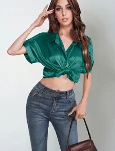 Detailed close-up showing the lustrous green satin short-sleeve shirt tied at the waist