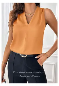 Close-up detail of a women's orange sleeveless satin V-neck blouse in a stylish outfit