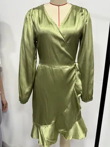 Detailed front view of green satin V-neck wrap dress with ruffled hem and long sleeves