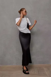 Detail view of an elegant black satin mermaid midi skirt with a smooth silky texture