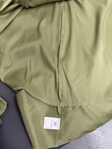 Close-up view showing the fabric texture and 100% polyester care label of a satin dress