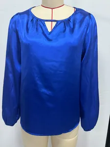 Vista detallada de una blusa de satén azul real con cuello en V y pliegues en un maniquí
