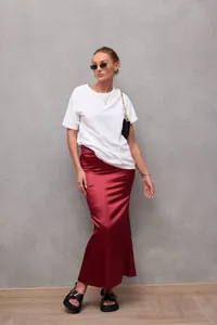 Detailed view of elegant wine red satin mermaid skirt with smooth glossy texture.